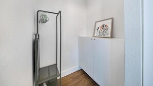 A corner room with a metal rack, a framed picture on the wall, and a white cabinet. - Art Deco Escape Steps to Ocean Free Parking (Miami Beach)