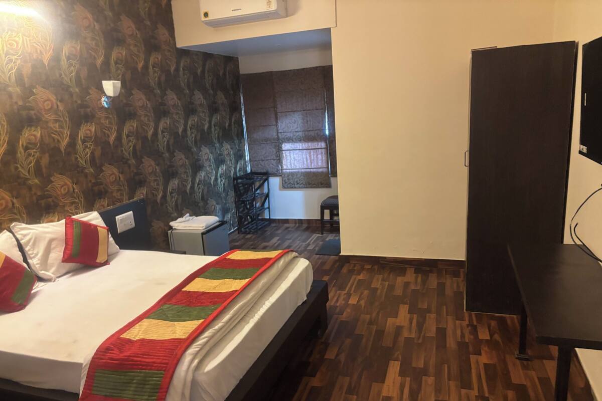 Una habitación de hotel con cama, escritorio, silla y televisor.