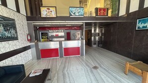 Una zona d'entrada amb sòl de marbre, una taulell de recepció i quadres als murs.