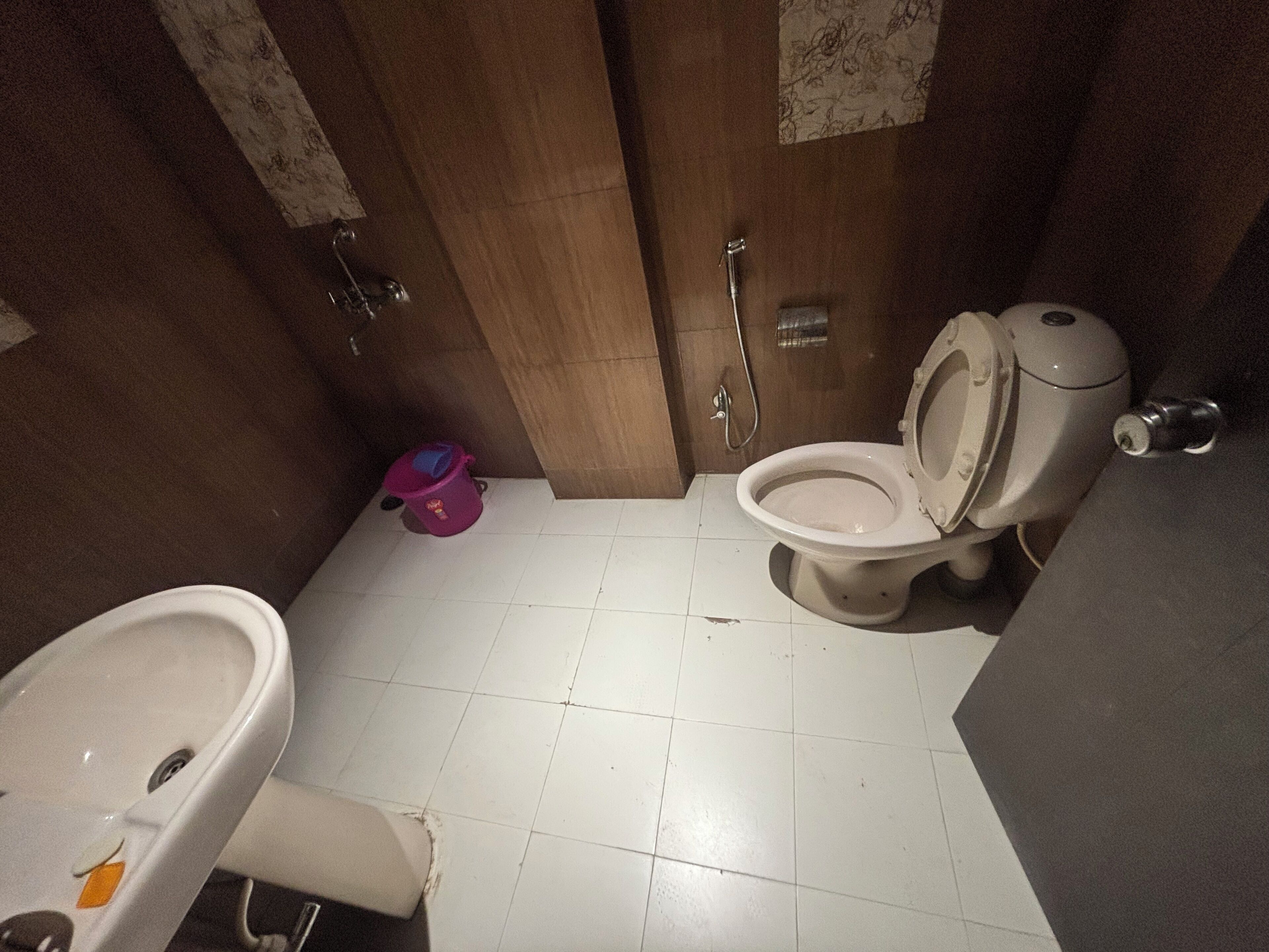 A small bathroom with a toilet, sink, and a shower.