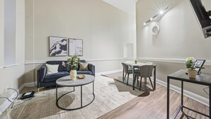 Ett modernt vardagsrum med en soffa, ett soffbord och en matplats.