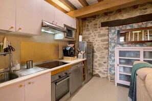 A compact kitchen with a built-in oven, a microwave, and a refrigerator. - Casa Rural 'Quimera' with Mountain Views and Balcony (Gil-García)
