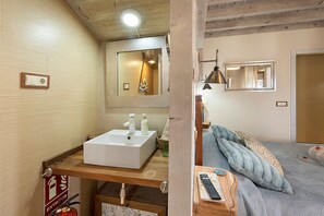 A bathroom with a white sink, a mirror, and a wooden vanity. - Casa Rural 'Quimera' with Mountain Views and Balcony (Gil-García)