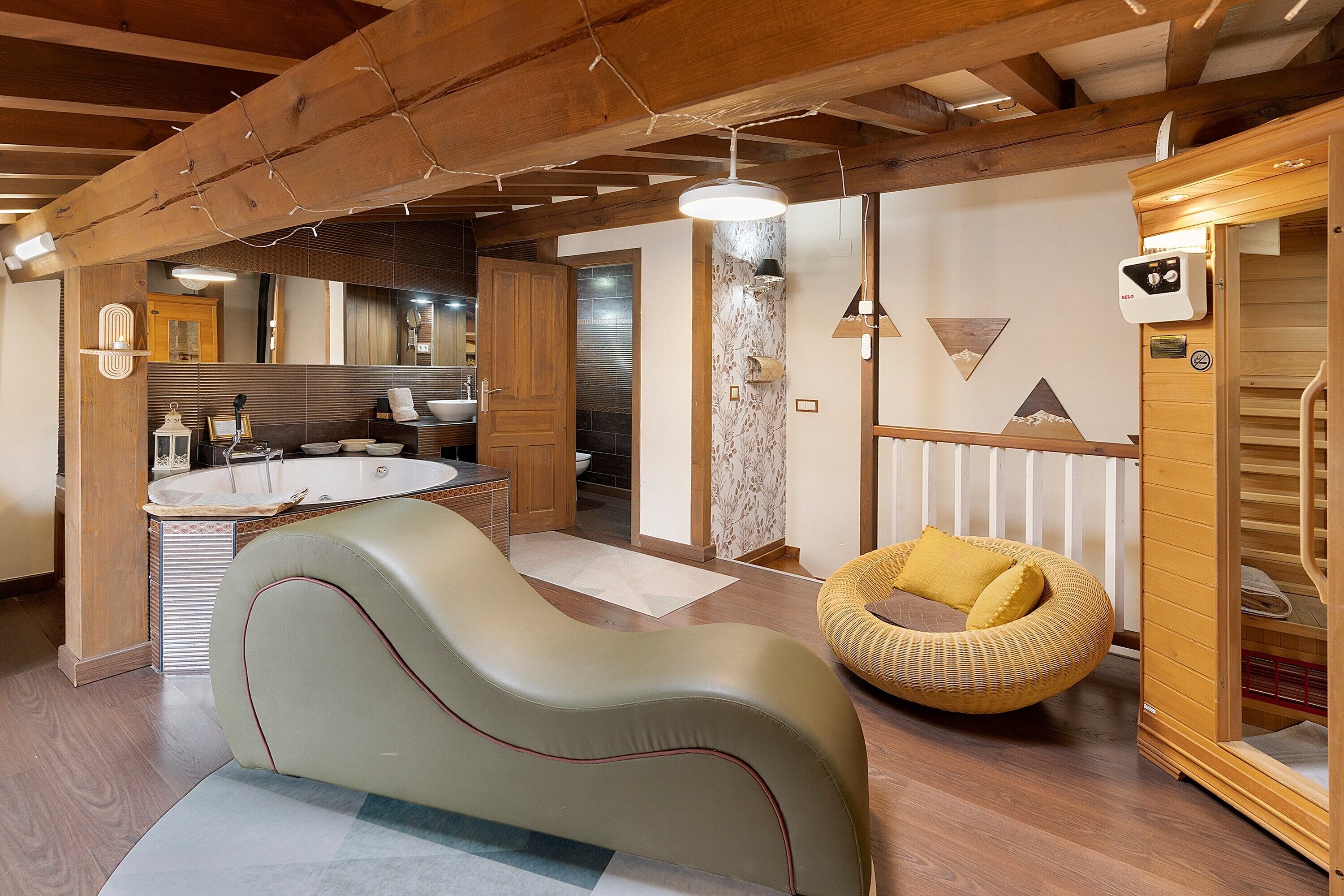 Een moderne badkamer met een bad, een houten bankje en een sauna.