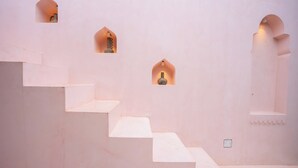 Un conjunto de escalones blancos que conducen a una plataforma con tres ventanas arqueadas, cada una con una lámpara.