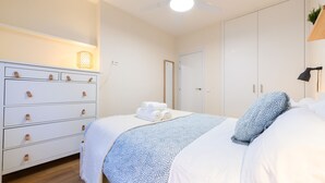 A bedroom with a bed, a dresser, a ceiling fan, and a door. - M Bso5 Apartamento Luminoso con 1 Dormitorio y e (Madrid)