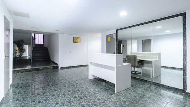 A reception area with a desk, a chair, and a staircase leading to another floor. - M Bso5 Apartamento Luminoso con 1 Dormitorio y e (Madrid)