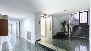 A hotel lobby with a marble floor, a staircase, and a potted plant. - M Bso5 Apartamento Luminoso con 1 Dormitorio y e (Madrid)