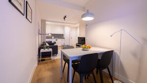 A compact living space with a dining area, kitchenette, and a sofa in the background. - M Bso5 Apartamento Luminoso con 1 Dormitorio y e (Madrid)