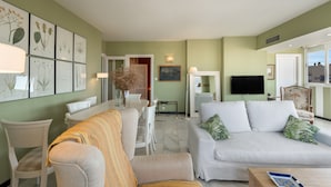 A living room with a sofa, chairs, a dining table, and framed botanical prints on the wall. - Marbella Center – 350m from the Beach (MARBELLA)