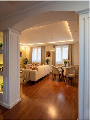 Ein geräumiges Wohnzimmer mit Sofa, Esstisch und Stühlen.