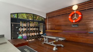 A gym with weightlifting equipment, a bench, and a wall-mounted life preserver. - Rockwell 220 by Ctha (Cape Town)