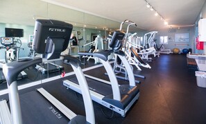 Ein Fitnessstudio mit Laufbändern, Kraftgeräten und Übungsbällen.