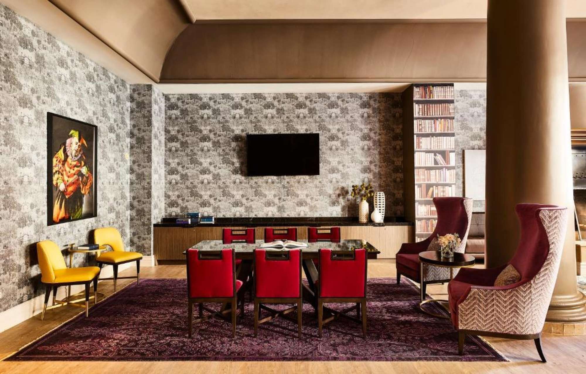 Ein Wohnzimmer mit Essbereich, einem wandmontierten Flachbildfernseher, einem Bücherregal und einem großen Fenster.
