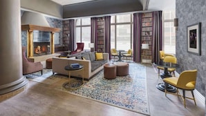 A spacious living room with a fireplace, a sofa set, a coffee table, and a bookshelf. - Steps to Union Square | Pet Friendly + Valet Parking (San Francisco)