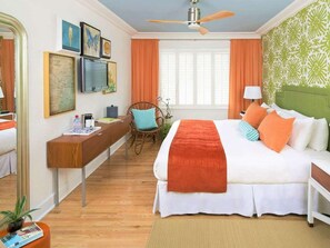 A hotel room with a bed, desk, chair, and a ceiling fan. - Miami Beach Access + On-site Dining. Pool. Bikes. (Miami Beach)