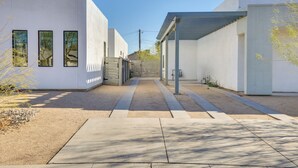 Un bâtiment moderne doté d’une allée couverte et d’un sentier de gravier.