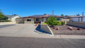 A single-story house with a front yard, a driveway, and a small garden with rocks and plants. - Private Pool & Patio! Home 8 Mi to Dtwn Phoenix (Phoenix)