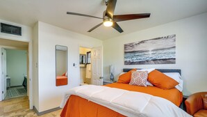 A bedroom with a bed, a ceiling fan, a painting of the ocean, and a door leading to another room. - Private Pool & Patio! Home 8 Mi to Dtwn Phoenix (Phoenix)