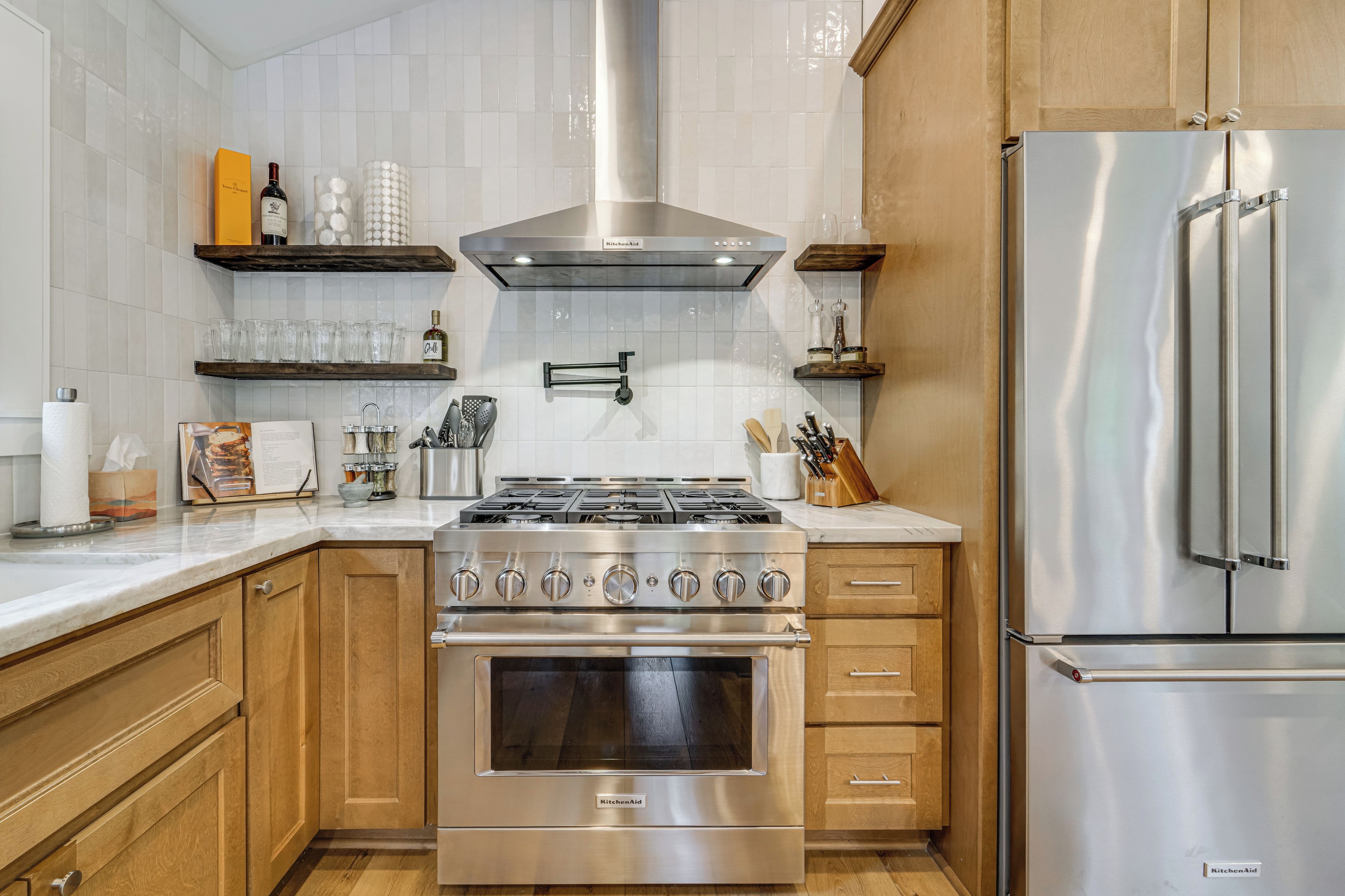 A kitchen with wooden cabinets, a stainless steel stove, and a refrigerator.