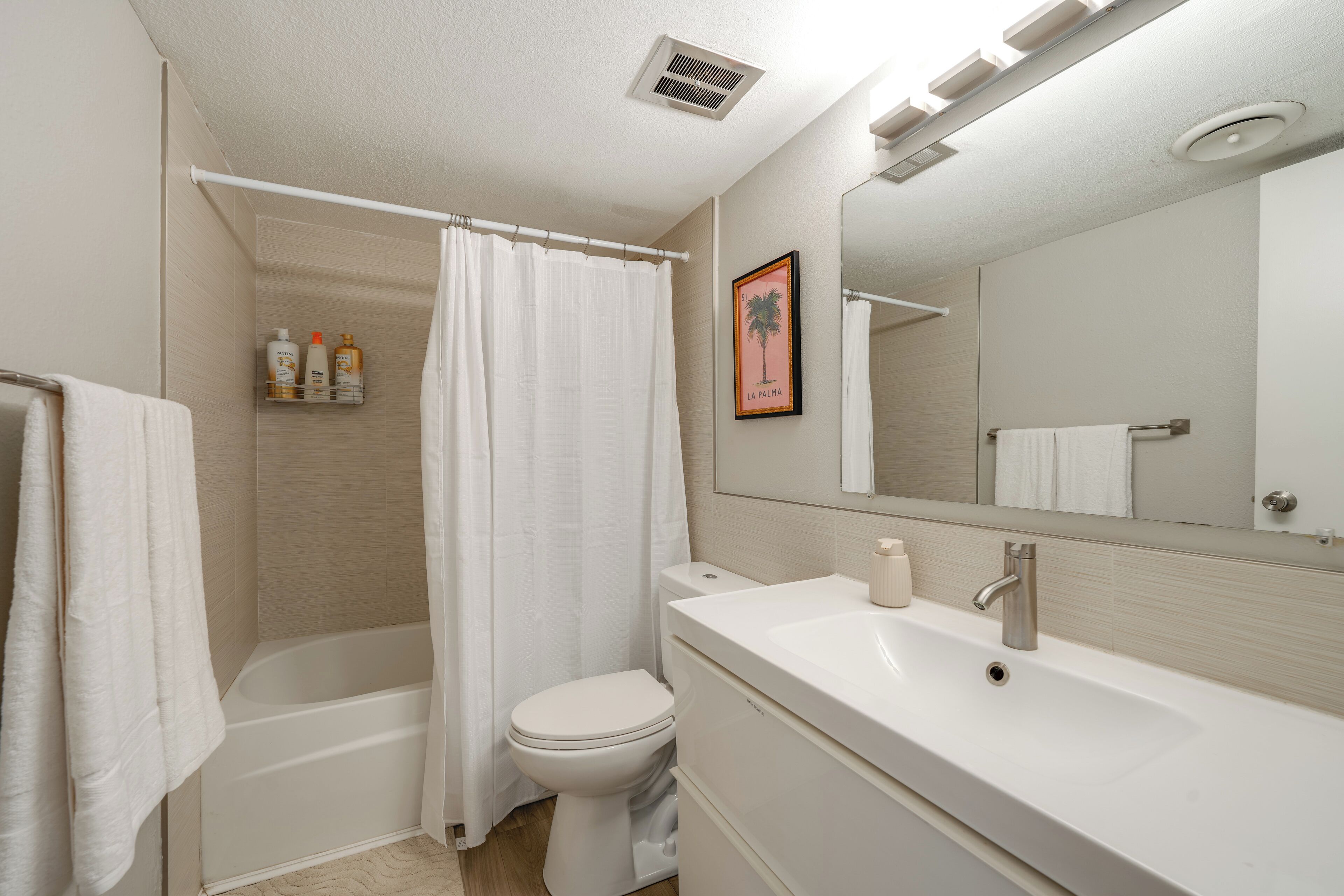 A modern bathroom with a bathtub, toilet, and sink.