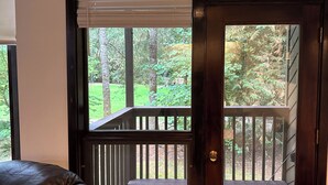 A wooden door with a view of a deck and a garden.