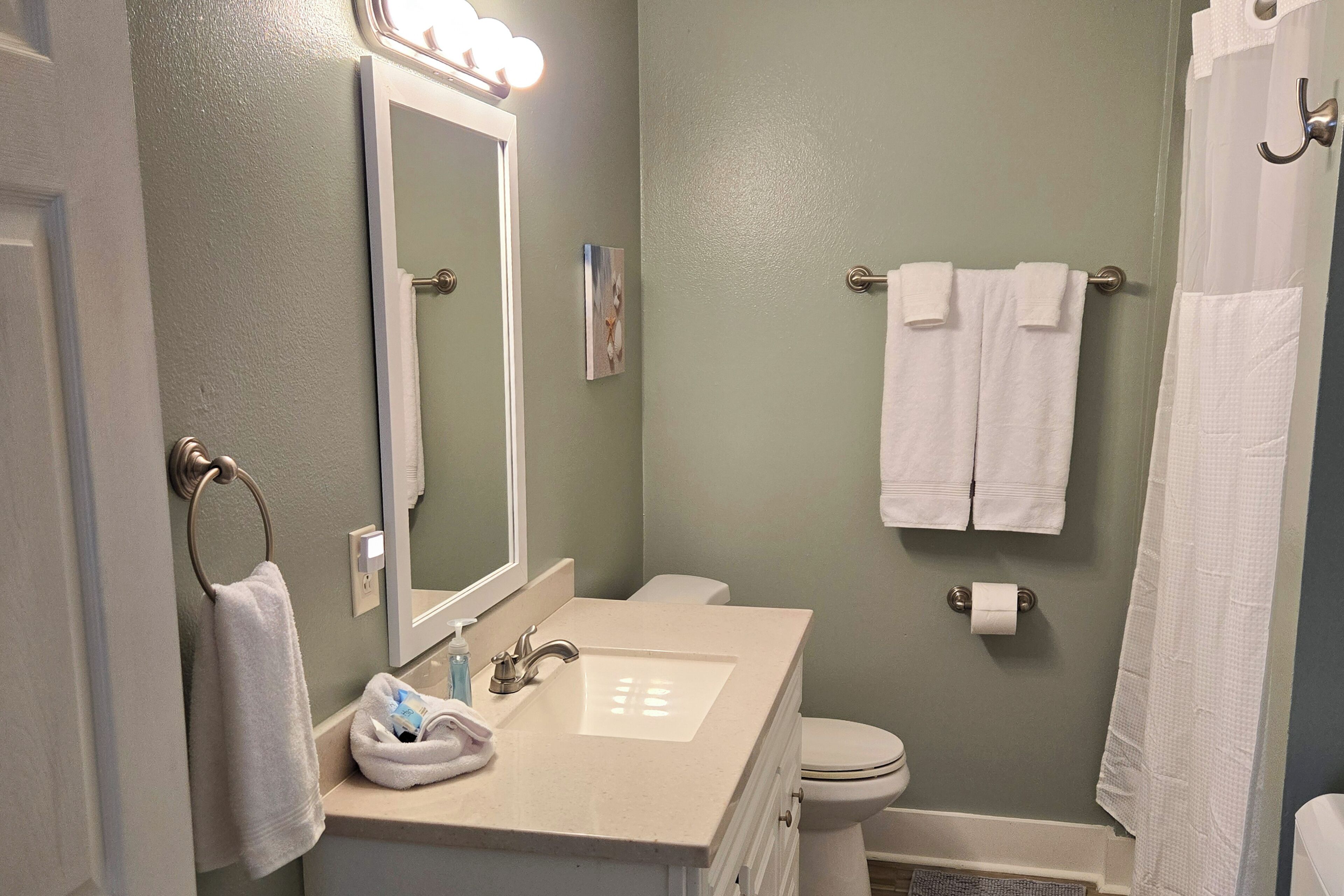 A bathroom with a sink, mirror, and towel rack.