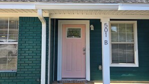 A house with a pink door, a 'hello' mat, and the number '501B' on the wall. - Cozy Duplex Spacious Close to Everything (Pensacola)
