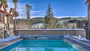 A swimming pool with a view of snow-covered mountains and pine trees. - Woodsy Winter Park Condo w/ Pool & Hot Tub Access (Winter Park)