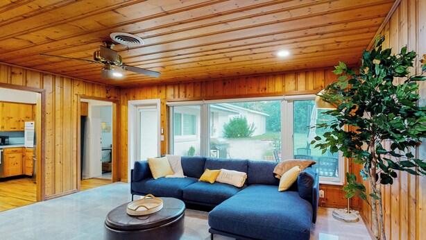 A modern living room with a sectional sofa, a coffee table, and a ceiling fan. - Steps to Lake Hollingsworth! Dog-friendly Retreat (Lakeland)