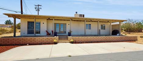 A single-story house with a flat roof, a front porch, and a garage.