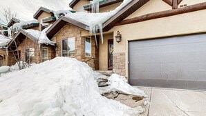 A residential building with a stone facade, a large garage door, and icicles hanging from the roof. - Steps to Brian Head Resort: Ski Home w/ Games (Brian Head)