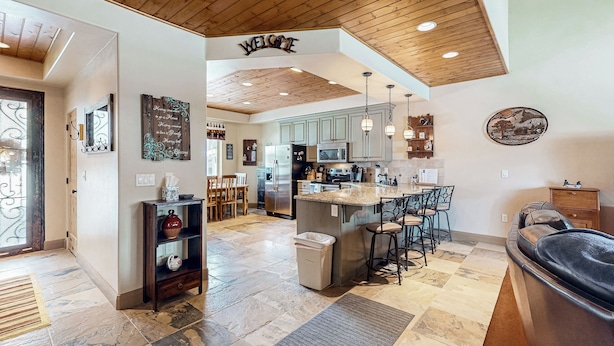 A spacious kitchen with a central island, wooden ceiling, and a 'WELCOME' sign. - Steps to Brian Head Resort: Ski Home w/ Games (Brian Head)