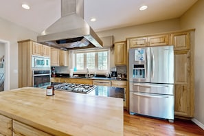 Una cocina moderna con armarios de madera, electrodomésticos de acero inoxidable y una isla grande.