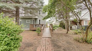A pathway leading to a house with a wooden deck and a brick walkway. - Game Room & Backyard: Modern Altoona Home! (Altoona)
