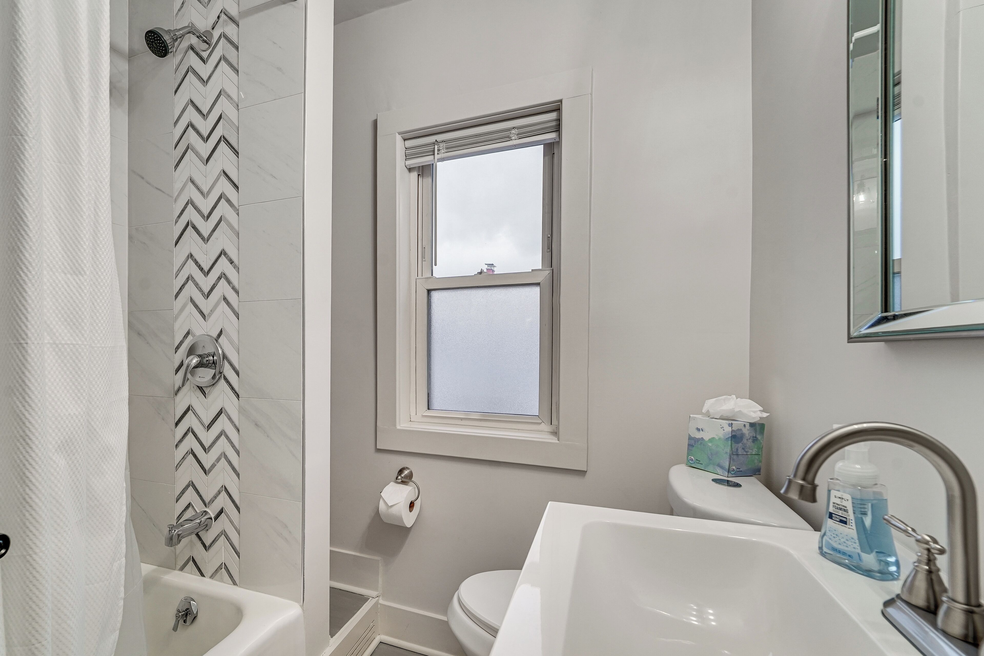 Une salle de bain avec douche, toilettes et lavabo.