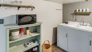A compact kitchen with a microwave, shelves with dishes, and a sink. - Couples Haven 1 Mi to Dtwn Dolores! Bring Your Pet (Dolores)