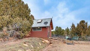 A small, single-story building with a sloped roof, a satellite dish, and a fenced outdoor area with a swing set. - Couples Haven 1 Mi to Dtwn Dolores! Bring Your Pet (Dolores)