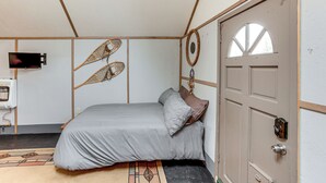 A room with a bed, a door, and a wall-mounted TV. - Couples Haven 1 Mi to Dtwn Dolores! Bring Your Pet (Dolores)