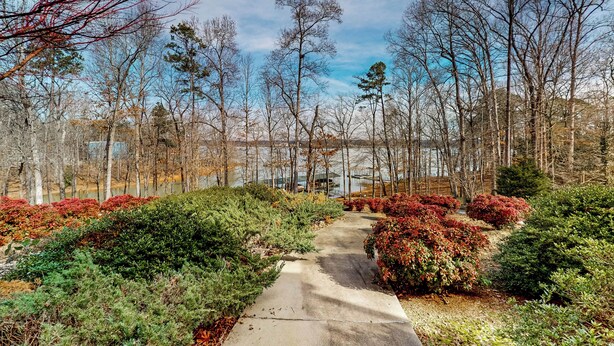 A concrete pathway leading through a landscaped area with various shrubs and trees. - Boat Dock: Lake-view Retreat 5 Mi to Dtwn Clemson (Seneca)