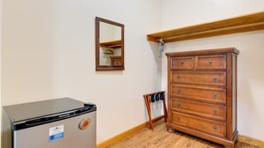 A room with a compact refrigerator, a wooden dresser, a mirror, and a coat rack. - Cozy Couples Getaway Near Cataloochee Ski Area! (Waynesville)