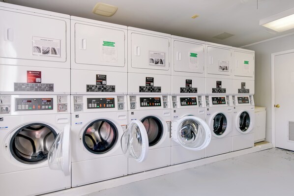 A row of white laundry machines with control panels and instructional signs. - Near Trails & Slopes! Relaxed Waynesville Retreat (Waynesville)