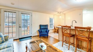 A living room with a blue leather chair, wooden dining table, and a kitchen area with wooden chairs. - Near Trails & Slopes! Relaxed Waynesville Retreat (Waynesville)