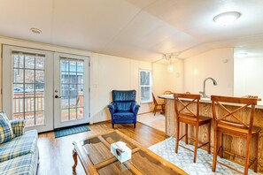 A living room with a blue leather chair, wooden dining table, and a kitchen area with wooden chairs. - Near Trails & Slopes! Relaxed Waynesville Retreat (Waynesville)