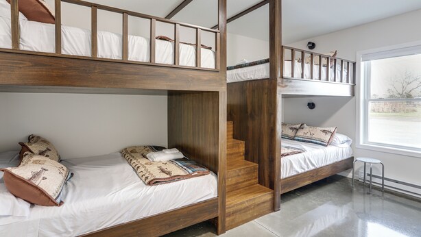 A bunk bed room with a wooden staircase connecting two levels. - Patio & Parking! Modern Bunkhouse Near Lake Erie (Oak Harbor)