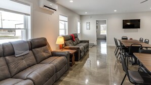 A modern living room with leather sofas, a dining table, and chairs. - Patio & Parking! Modern Bunkhouse Near Lake Erie (Oak Harbor)