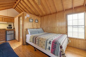 A wooden cabin with a bed, a small kitchenette, and a window. - Escape to Blue Ridge Mtns! Studio w/ Resort Perks (Waynesville)