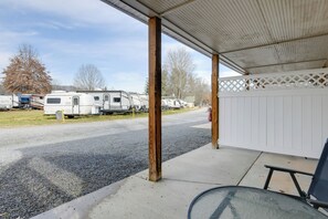 A covered outdoor area with a concrete floor, wooden pillars, and a white fence. - Accessible Waynesville Studio Near Blue Ridge Pkwy (Waynesville)