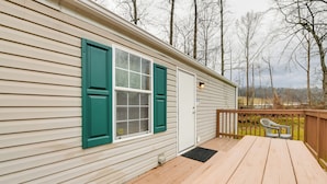 A wooden deck with a picnic table and two chairs, a door with green shutters, and a view of trees in the background. - Mtn-view Adventure Hub! Waynesville Home w/ Perks (Waynesville)