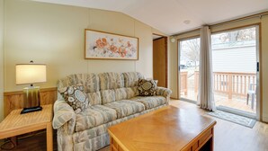 A living room with a sofa, a wooden coffee table, a lamp, and a painting on the wall. - 13 Mi to Slopes! Group-friendly Blue Ridge Retreat (Waynesville)